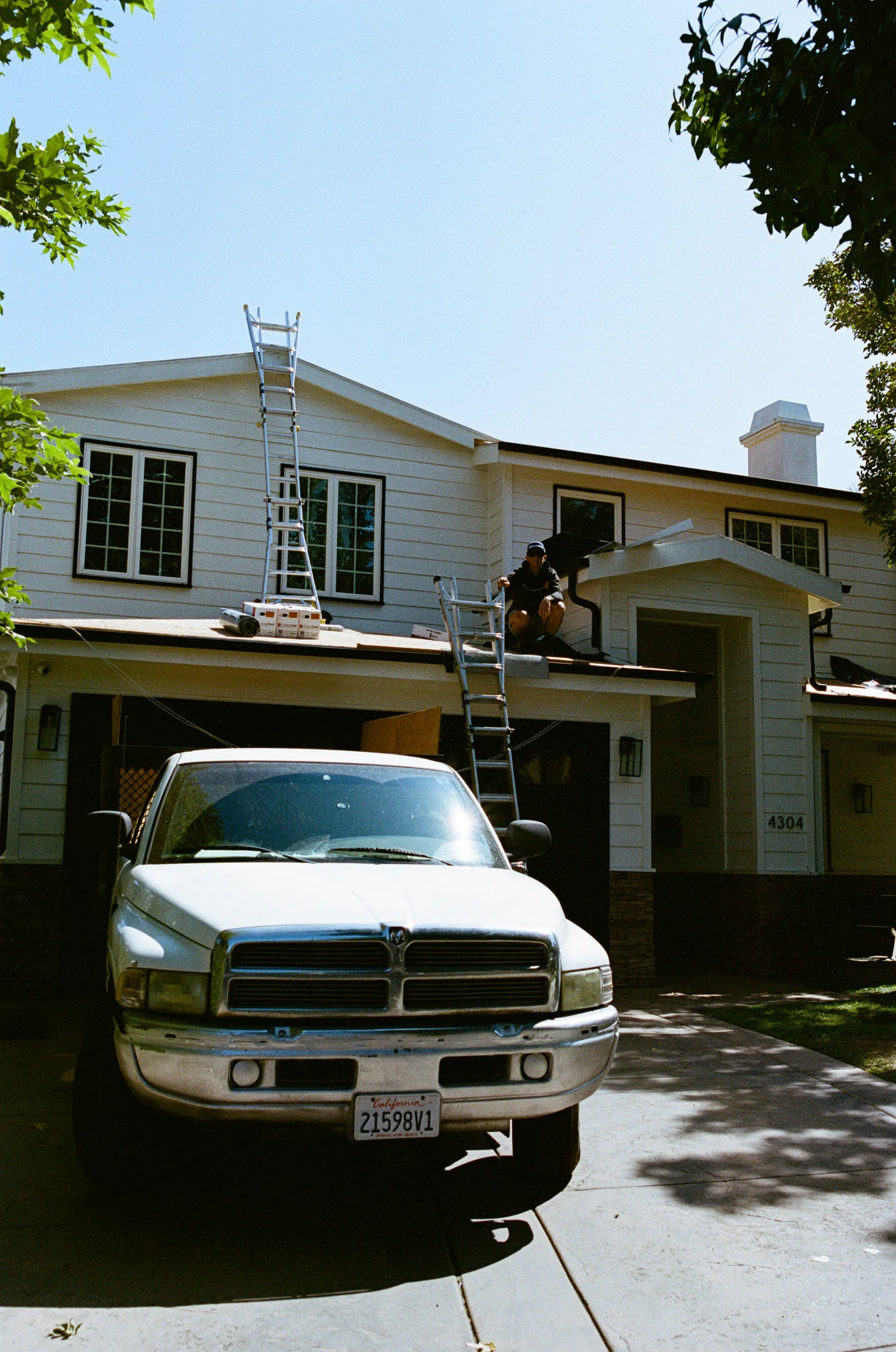 Roofing ladders and a Swell roofer at a Southern California home